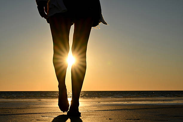 istock Woman walk on the beach at sunset 2231034892