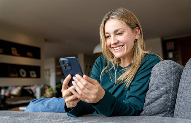 istock Happy woman relaxing at home using her cell phone and smiling 2231040564