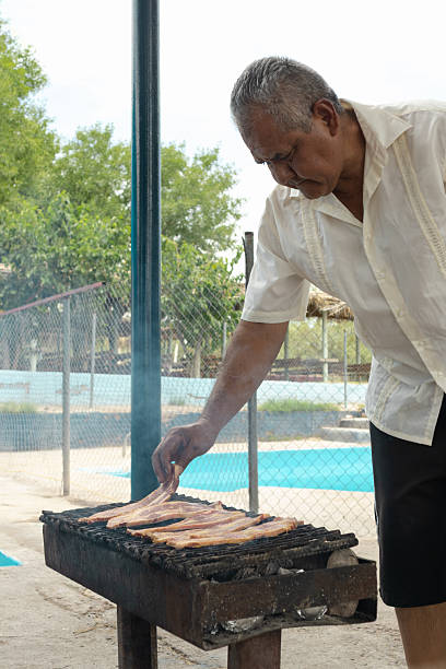 istock Latin man grilling beef ribs outdoors in northern mexico 2231047382