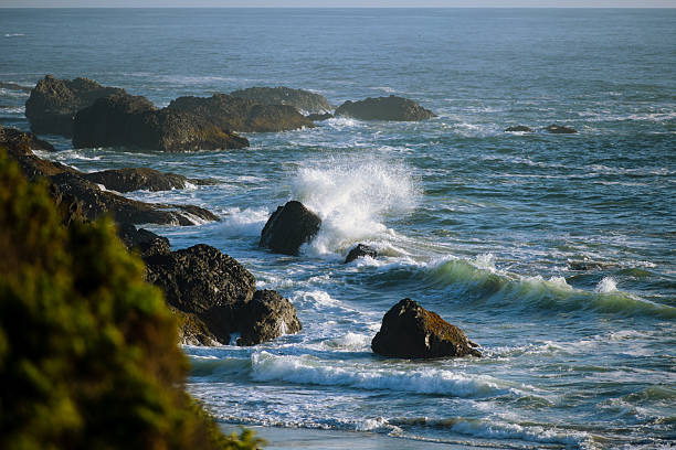 Sea waves crashing on coastal rocks on the shoreline.