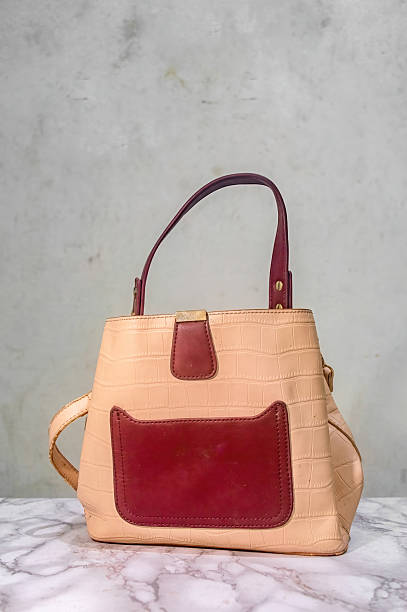 istock Elegant handbag in light beige with a crocodile skin pattern, featuring a striking burgundy pocket and handle, blending classic style with modern design elements for women fashion 2231056648