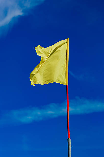 istock Yellow Flag Against Clear Blue Sky 2231056663