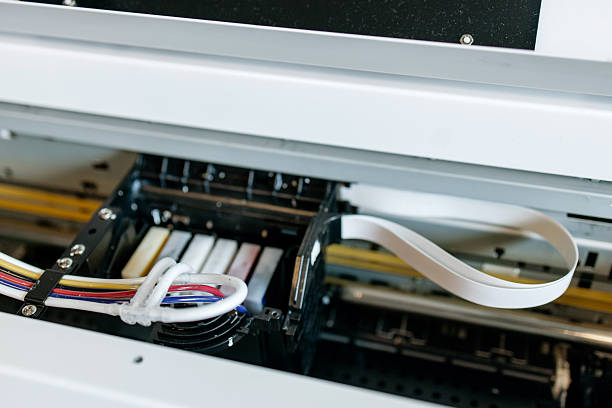 istock Close-up view of a professional inkjet printer during maintenance process, showing ink cartridges, printhead and ribbon cable inside industrial printing equipment 2231059245