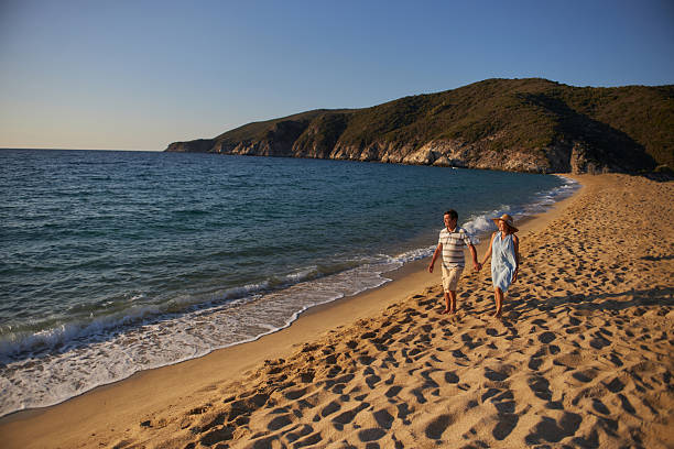 Senior couple enjoying sunrise on a beach vacation. Active seniors.