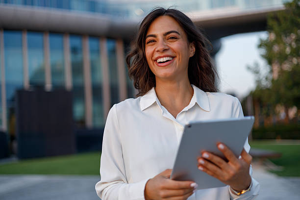 istock Professional businesswoman walking confidently near office, using digital tablet and connecting with mobile technology 2231068044