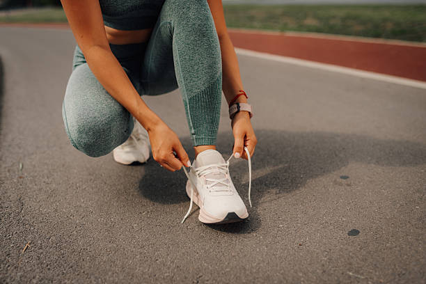 istock Female athlete tying shoelaces on running track 2231068700
