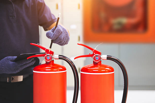 istock Fire extinguisher has hand engineer inspection checking pressure gauges to prepare fire equipment for protection and prevent emergency and safety rescue and alarm system training concept. 2231069208