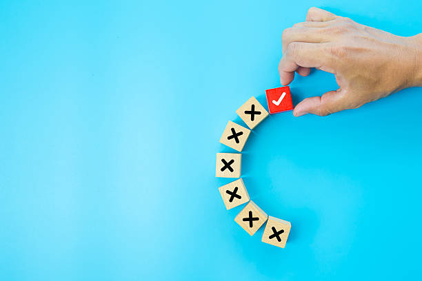istock Hand choose check mark on cube wooden toy block with cross symbol for true or false changing mindset or way of adapting to change leader and transform quiz answer and poll concept. 2231069241