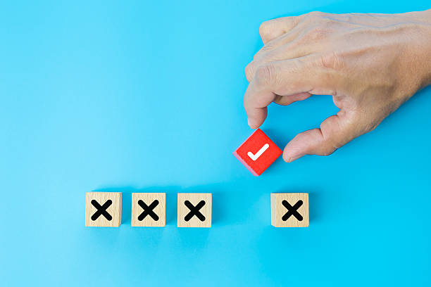 istock Hand choose check mark on cube wooden toy block with cross symbol for true or false changing mindset or way of adapting to change leader and transform quiz answer and poll concept. 2231069985