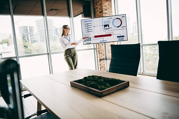istock Charming businesswoman presenting a professional report on a digital display in a modern glass-walled office 2231071836