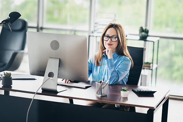 istock Confident young businesswoman working diligently on a computer in a modern office environment with natural light 2231073061