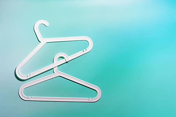 istock Top view White Plastic hangers, minimal style layout on white teal gradient background, Clothes rack for organizing clothes in closets or retail stores, fashion, organization concept, copyspace 2231074247