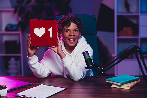 istock Positive content creator in a vibrant workspace holding a love symbol showcasing interactive online engagement 2231076701