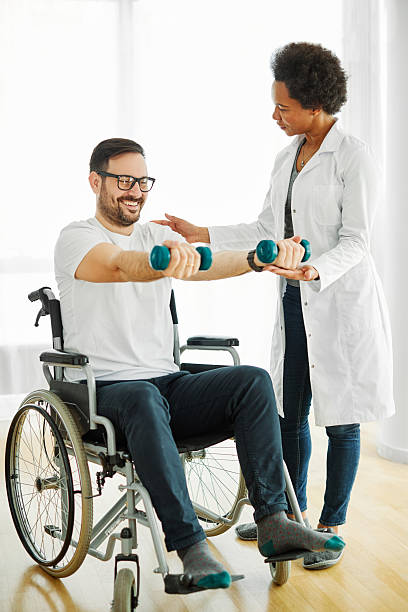istock disability wheelchair disabled man handicap exercise training home dumbbell physical therapy recovery therapist doctor nurse rehab lifting weight 2231076817