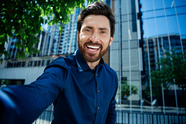 istock Young confident businessman taking a selfie outdoors with urban background, showcasing a positive and professional demeanor 2231077168