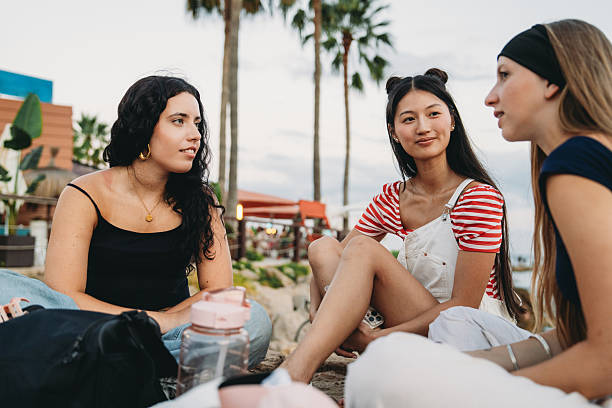 istock Young women chatting together on the beach 2231079120