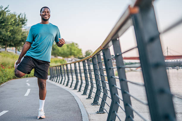 istock Young man stretching legs before running near river 2231079342