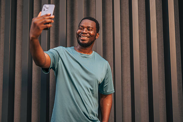 istock Young man taking a selfie with smartphone in front of a modern building 2231079473