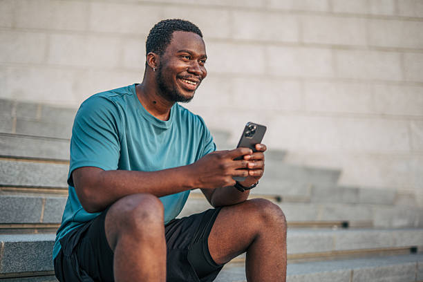 istock Young sportsman resting and using phone on urban steps 2231079586