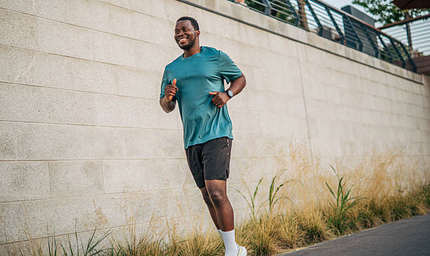 istock Young man jogging outdoors in urban setting, enjoying his workout 2231080266