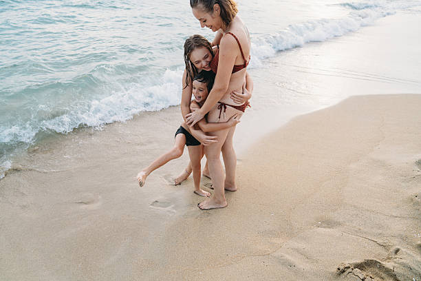 istock Mother hugging children on the beach 2231081582
