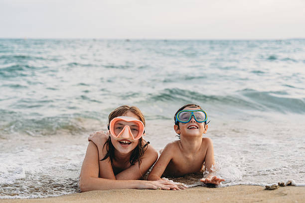 istock Children wearing diving masks lying on the beach 2231081587