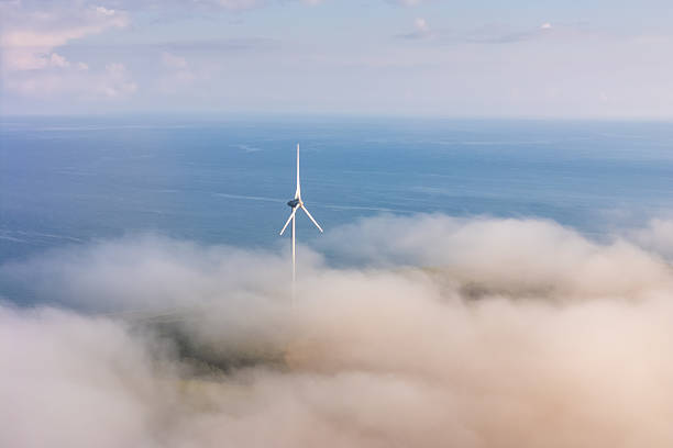 Low clouds and fog with wind turbines visible in the sea of clouds high up aerial view in Hokkaido.