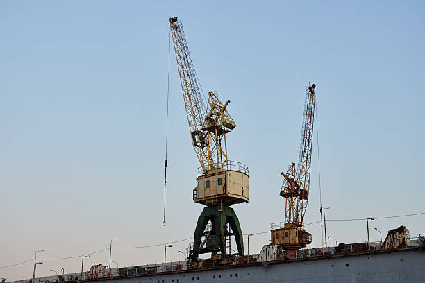 A stunning view of towering cranes in a bustling shipyard against a clear blue sky, symbolizing maritime industry