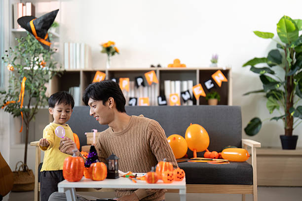 istock Halloween Celebration. Father and son enjoying festive pumpkin decorations together. 2231090696