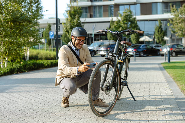 istock Man wearing helmet inspecting a bicycle outdoors on a sunny day 2231092169