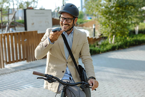 istock Smiling businessman on bicycle making phone call outdoors in an urban environment 2231092276