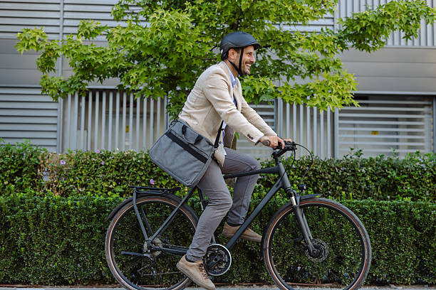 istock Man commuting on a bicycle wearing a helmet and carrying a shoulder bag 2231092619