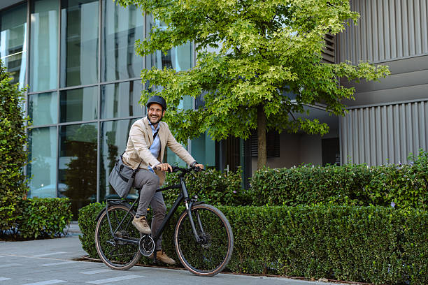 istock Man commuting on a bicycle wearing a helmet and carrying a shoulder bag 2231092656