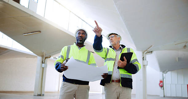 istock Construction, pointing and men with blueprint in building for collaboration, project ideas and renovation. Engineering, architecture team and people with documents for floor plan, layout and design 2231092865
