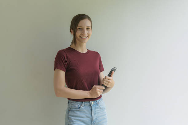 Positive and confident female student posing with a tablet, looking at the camera, smiling.