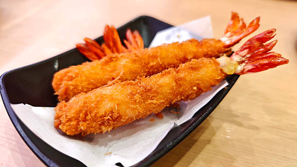 istock Breaded Torpedo shrimps on black plate 2231097704