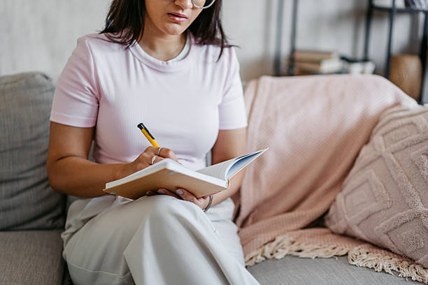 istock Young Indian Woman Writing In A Diary At Home 2231097980