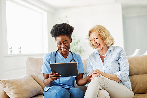 istock nurse doctor senior care tablet computer technology showing caregiver help assistence retirement home nursing elderly woman african american black happy laughing 2231098226
