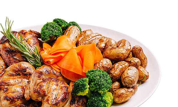 A colorful dish featuring grilled chicken pieces alongside roasted golden potatoes, bright green broccoli, and elegant carrot ribbons. Perfectly presented for a healthy meal.