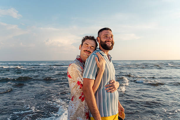 istock Happy couple enjoying a sunset on the beach 2231099675