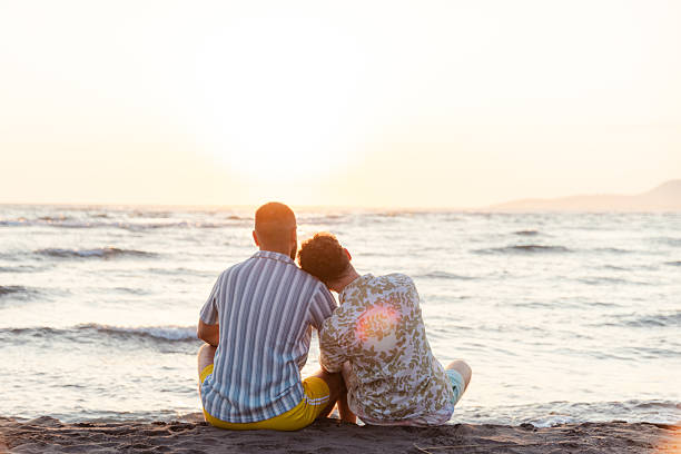 istock Couple relaxing on a beach during a beautiful sunset 2231099951