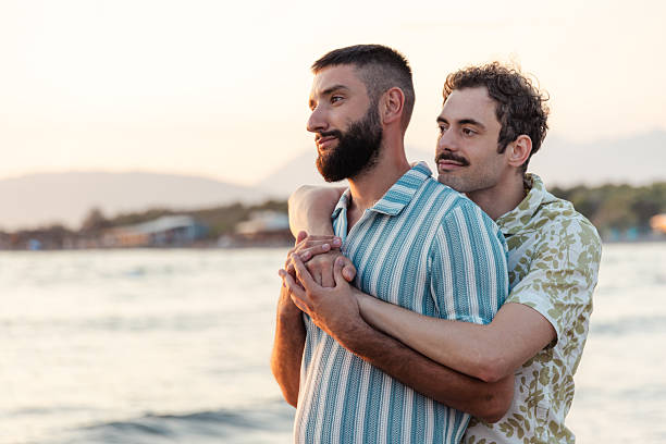 istock Loving couple embracing by the seaside during a romantic sunset 2231099992