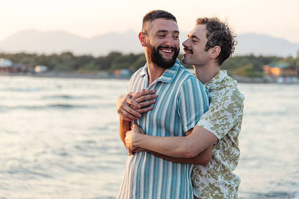 istock Happy couple embracing by the sea during sunset 2231099997