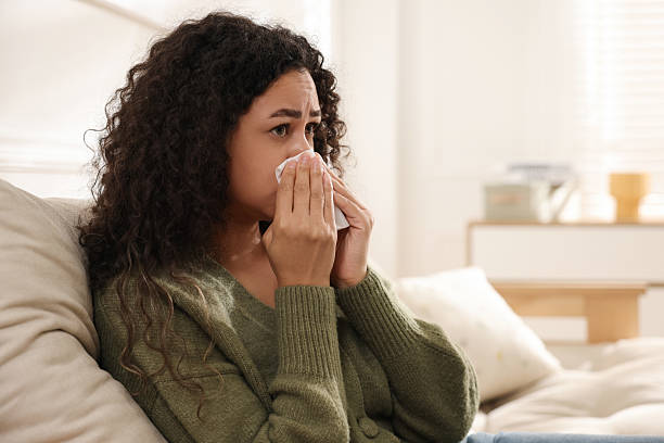 istock Young woman with tissue blowing runny nose at home. Space for text 2231103225