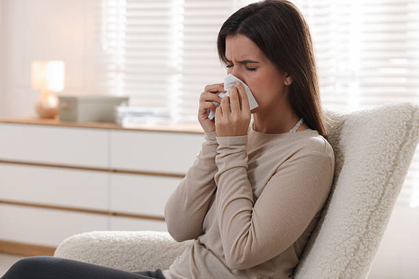 istock Young woman with tissue blowing runny nose at home. Space for text 2231103227