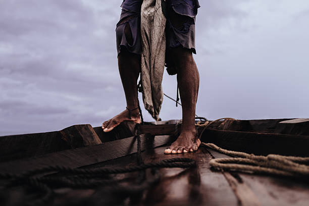 Fisherman feet by the boat sail