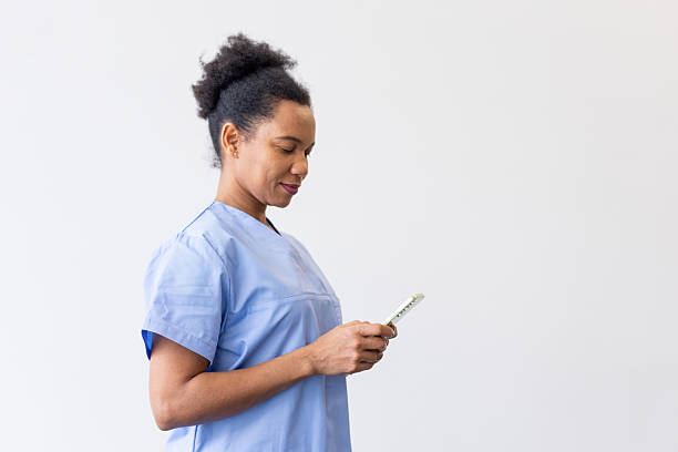 istock Confident female doctor smiling while using a mobile phone, engaging with the screen and showcasing a positive demeanor 2231105849