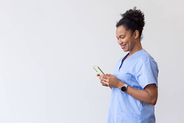 istock Friendly nurse in blue scrubs checking smartphone, radiating professional satisfaction during hospital shift 2231105853