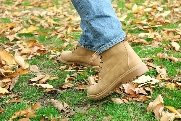 istock Man walking on green grass with fallen leaves, closeup 2231107056