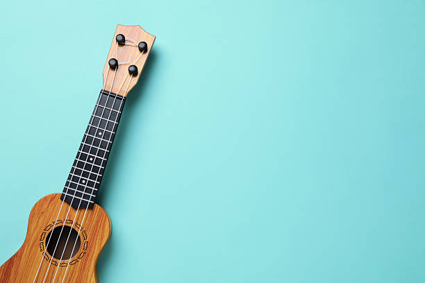 istock One ukulele on turquoise background, top view. Space for text 2231107882
